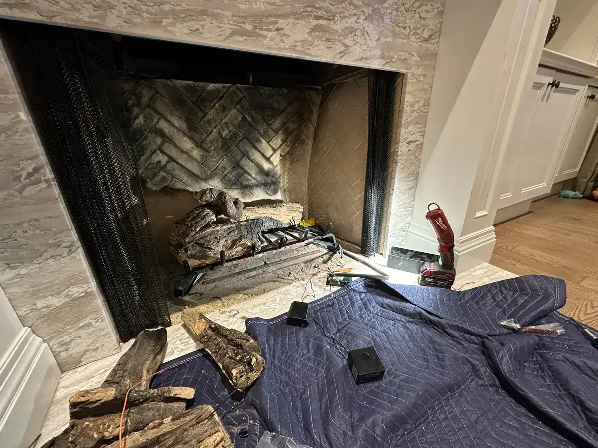 Gas fireplace opened for service with drop cloth down