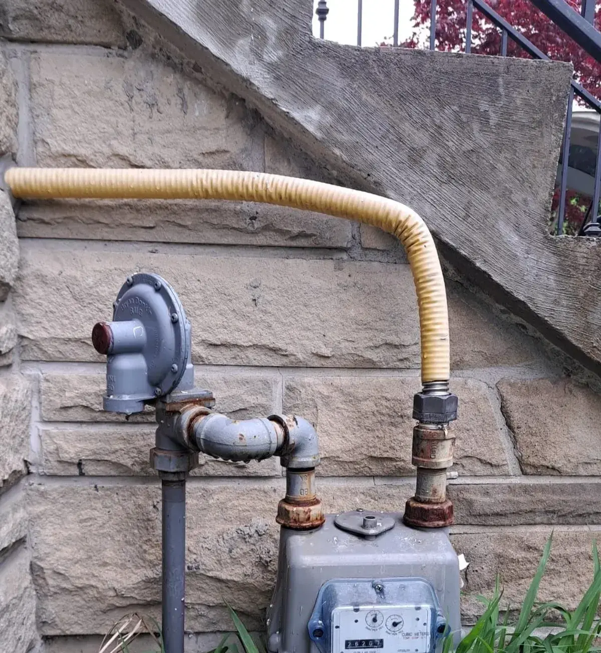 Gas meter with new flex connector on a stone wall