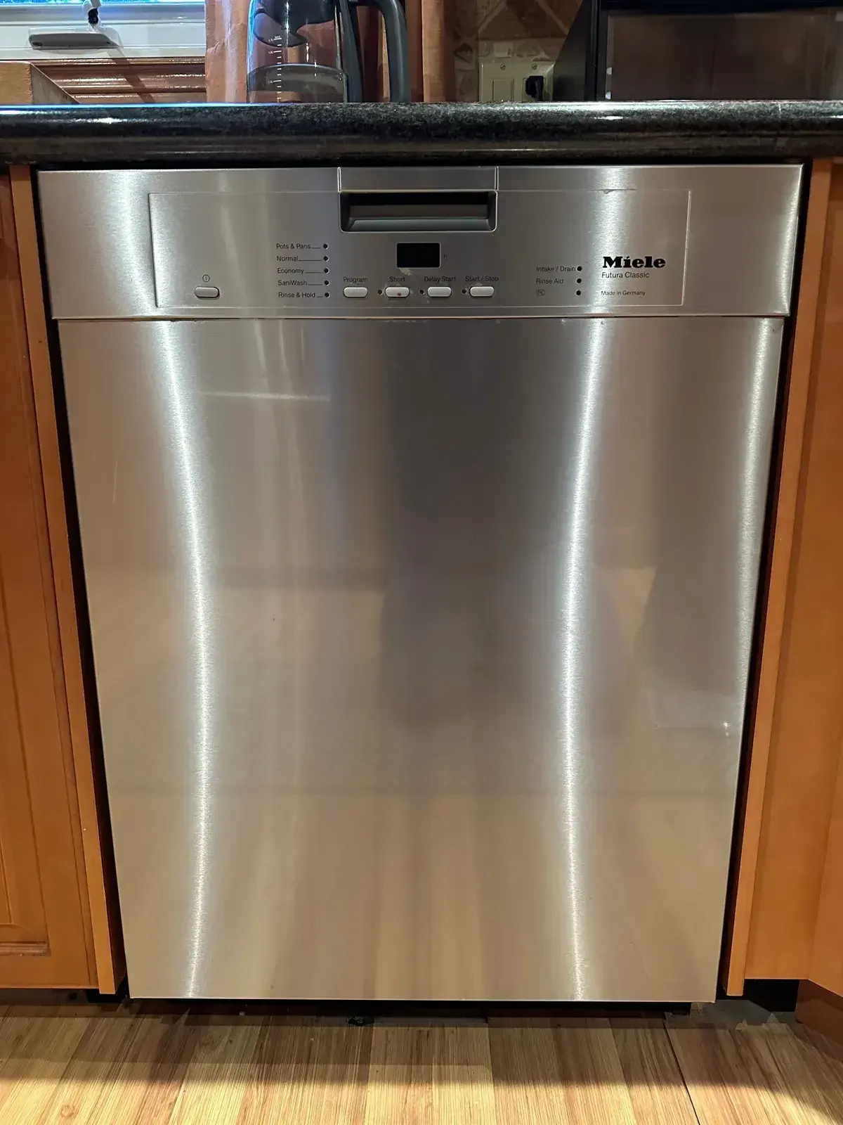 Miele dishwasher installed in wood cabinetry