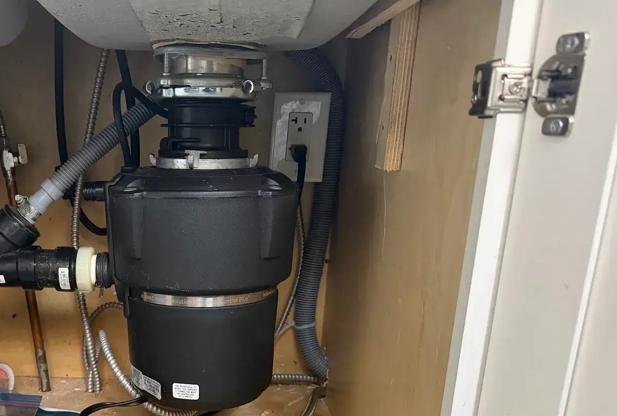 InSinkErator garbage disposal and new pipework installed under a kitchen sink